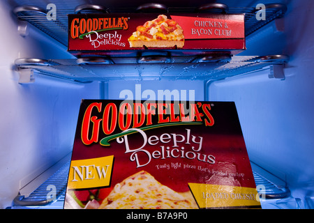 A man taking out a Goodfellas pizza from a deep freezer Stock Photo