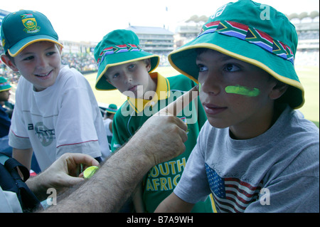 Three boys supporting the South African Cricket side having their face painted in the South African colours Stock Photo