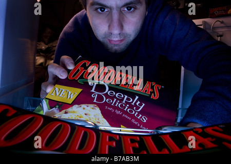 A man taking out a Goodfellas pizza from a deep freezer Stock Photo