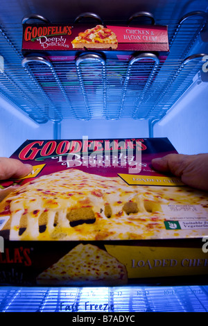 A man taking out a Goodfellas pizza from a deep freezer Stock Photo