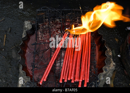 Votive candles burning over a container of wax, Cebu Cathedral, Philippines Stock Photo