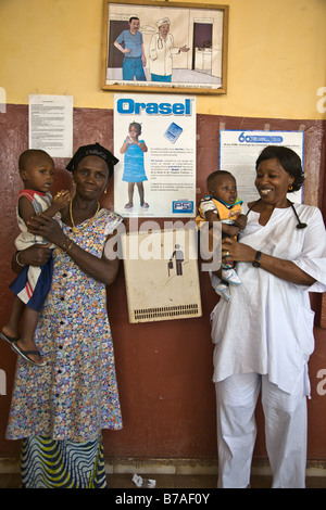 Children at a health center in Conakry, Guinea.  The poster on the wall advertises Orasel, oral rehydration salts (ORS). Stock Photo
