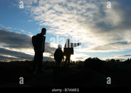 A family gaze out on the view of Brimham Rocks North Yorkshire at sunset on a winter's day Stock Photo