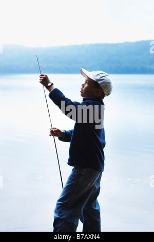 Boy Adjusting Fishing Rod, Algonquin Park, Ontario, Canada Stock Photo
