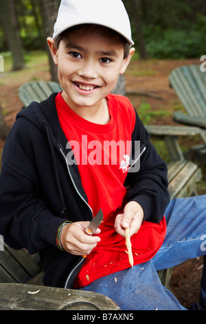 Boy Carving a Stick With His First Pocket Knife, Algonquin Park, Ontario, Canada Stock Photo