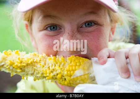 Girl Eating Corn on the Cob, Chicago, Illinois, USA Stock Photo