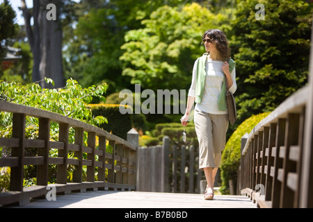 Woman Walking Across Bridge at the Japanese Tea Garden in Golden Gate Park, San Francisco, California, USA Stock Photo