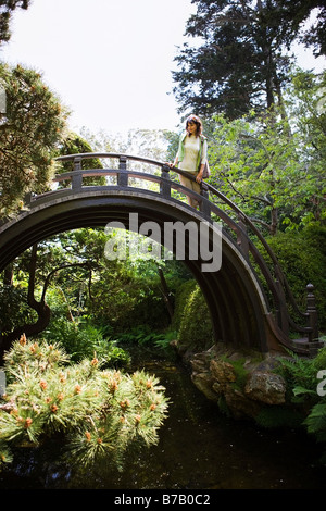 Woman Walking Across Bridge at the Japanese Tea Garden in Golden Gate Park, San Francisco, California, USA Stock Photo