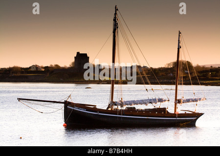 Galway hooker in kinvara with dunghaire castle in the background Stock Photo