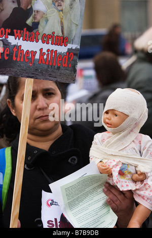 woman holding doll protesting against Israeli incursion into Gaza Stock Photo