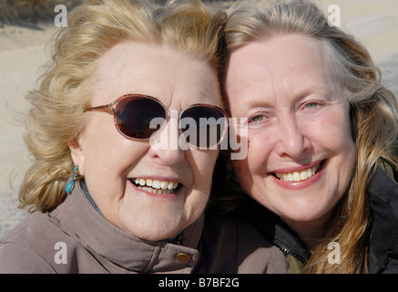 An elderly lady in her eighties poses for a picture with her beautiful sixties daughter Stock Photo