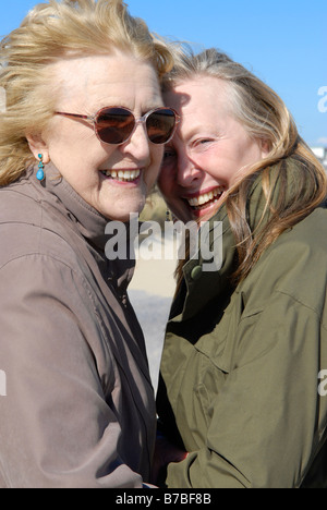 An elderly lady in her eighties poses for a picture with her beautiful sixties daughter.Both are having fun and laughing. Stock Photo