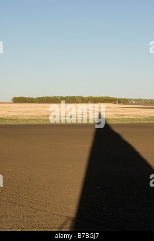 Long shadow of wind turbine on ground Stock Photo
