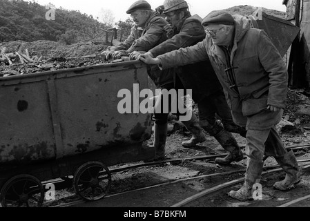 Miners pushing tram of coal on surface at Blaencuffin coal mine a privately owned drift mine above Pontypool South Wales UK Stock Photo