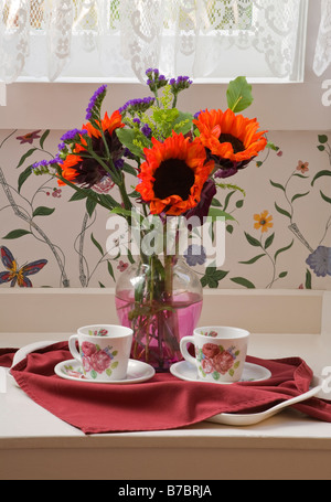 COFFEE is served on a tray with a bouquet of RED SUN FLOWERS in a VICTORIAN BED AND BREAKFAST PACIFIC GROVE CALIFONRNIA Stock Photo