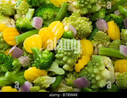 mixed vegetables background consisting of broccoli florets, red onion pieces, green beans, yellow carrot slices, romanesco Stock Photo