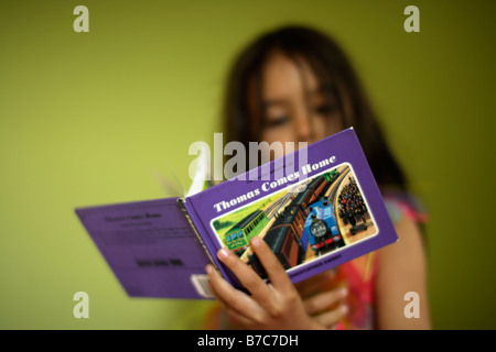 Girl reads Thomas Tank engine story book Stock Photo