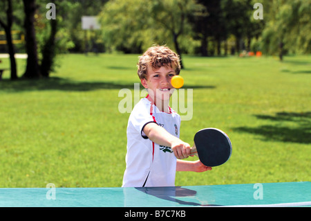 boy playing table tennis outdoors Stock Photo