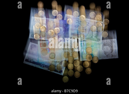 Falling blurred UK currency money, banknotes and pound coins sterling to illustrate the falling pound