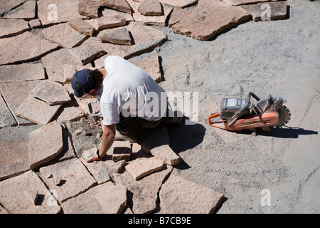 Man laying limestone slabs on a terrace Stock Photo