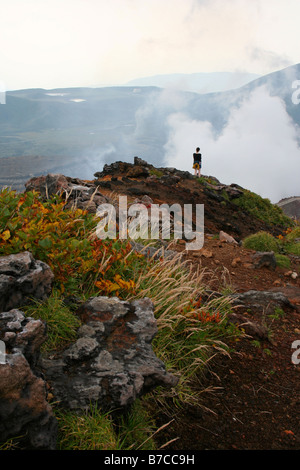 Walker standing by a rising steam cloud from active volcano Aso (Mount Aso (阿蘇山, Aso-san, Mt Aso), Kyushu, Japan Stock Photo