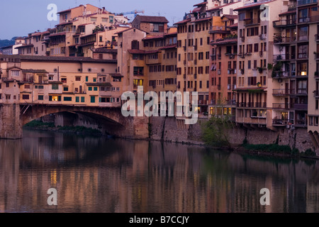 Jumble of buildings on the Ponte Vecchio and along the River Arno at dusk in Florence Italy Stock Photo