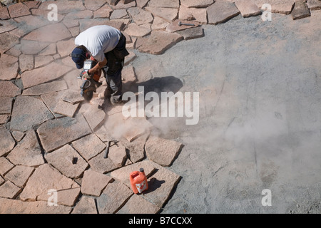 Man cutting and laying limestone slabs on a terrace Stock Photo