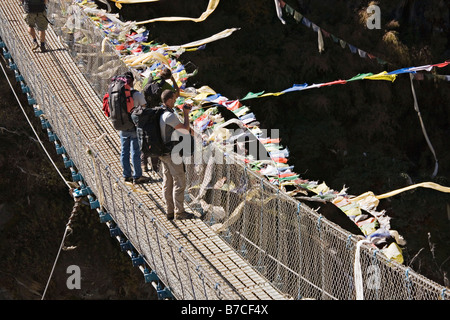 Travelers on steel cable suspension bridge over Dudhkoshi river on the way to Namche Bazar in Everest Valley Nepal Stock Photo