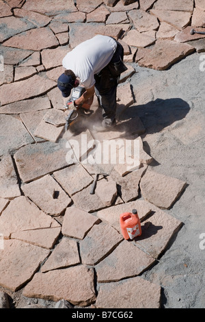 Man cutting and laying limestone slabs on a terrace Stock Photo