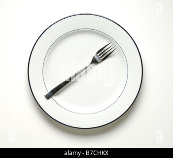 A round white dinner plate with a fork Stock Photo