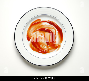 Red ketchup smeared on a round dinner plate Stock Photo