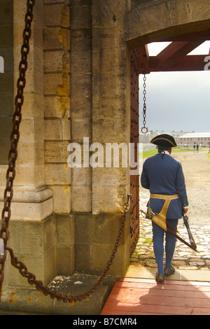 An actor in period dress stands guard over the main gate entering the Fortress of Louisbourg, Cape Breton, Nova Scotia. Stock Photo