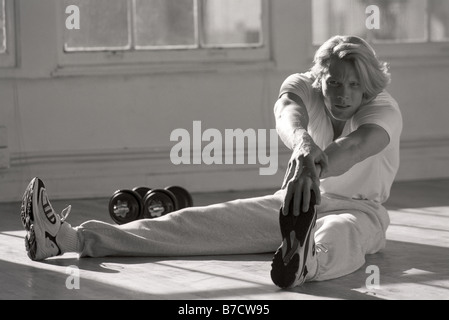 Man stretching in gym Stock Photo