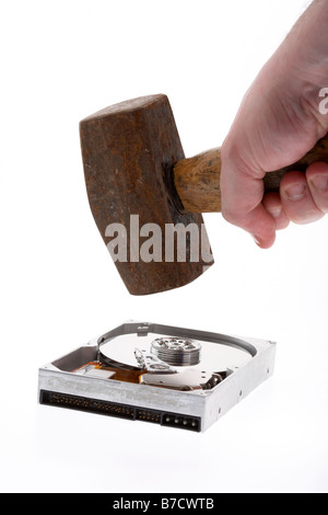 mans hand holding old sledge hammer over a computer hard drive on white background Stock Photo