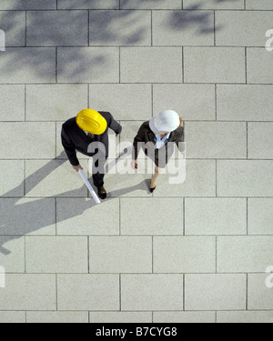 Two business people wearing hard hats Stock Photo