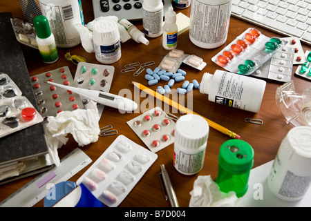 An office desk cluttered with various medicines Stock Photo