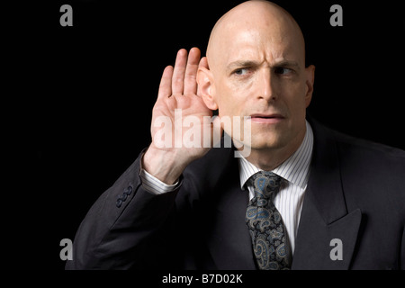 A man holding his hand to his ear Stock Photo