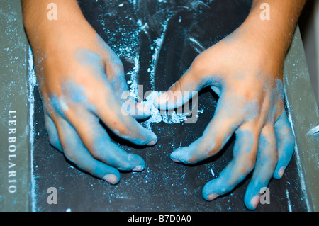 Child s hands covered in dirty blue gypsum Stock Photo