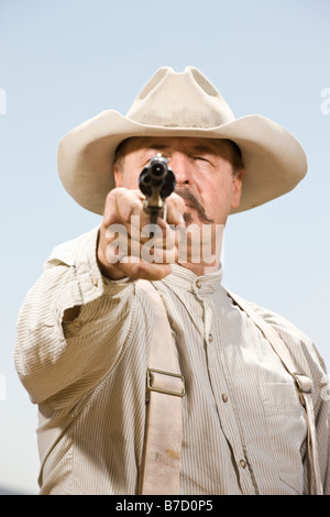 Portrait of a cowboy aiming his gun ready to shoot Stock Photo