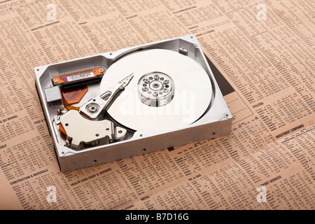 opened computer hard drive sitting on a copy of the financial times concept for it computing technology sector investing investments open security Stock Photo
