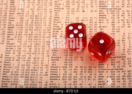 pair of dice sitting on share information in a copy of the financial times Stock Photo