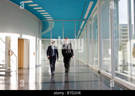 Two businessmen walking in the foyer of a convention center Stock Photo