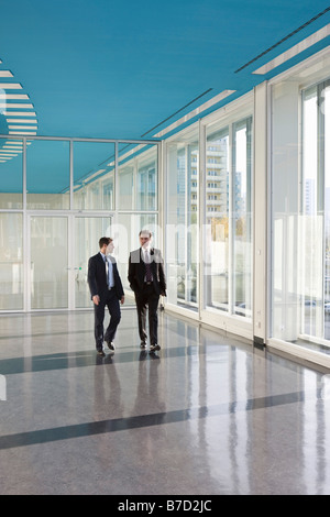 Two businessmen walking in the foyer of a convention center Stock Photo