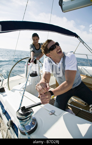 A couple adjusting the rigging on a yacht Stock Photo