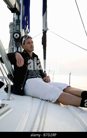 A man sitting on deck of a yacht Stock Photo
