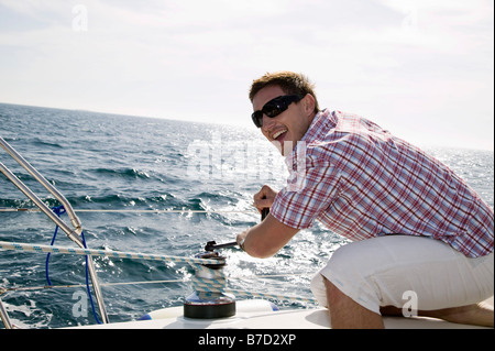 A man adjusting the rigging on a yacht Stock Photo