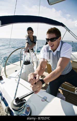 A couple adjusting the rigging on a yacht Stock Photo