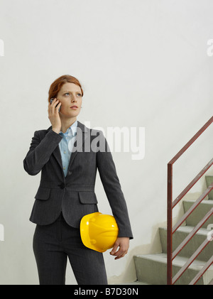 An architect talking on a mobile phone on a building site Stock Photo