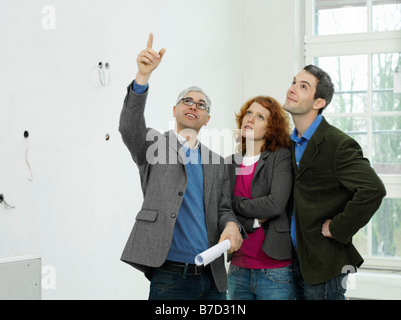 An architect going over blueprints with a young couple Stock Photo