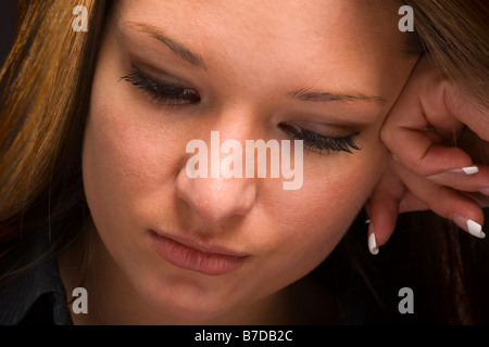 Close up of attractive young woman looking down with serious expression Stock Photo